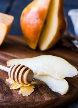 Peynir ve ballı bir ahşap tahta üzerinde taze sulu armut