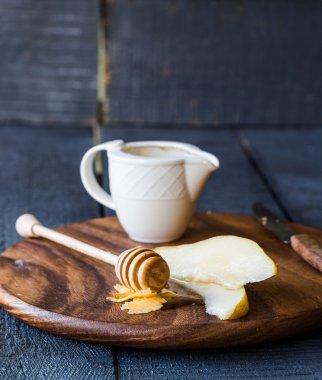 Peynir ve ballı bir ahşap tahta üzerinde taze sulu armut