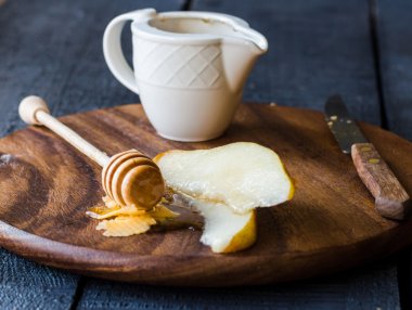 Peynir ve ballı bir ahşap tahta üzerinde taze sulu armut