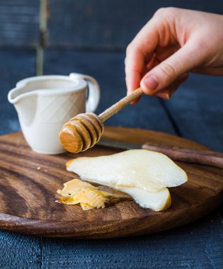 Peynir ve ballı bir ahşap tahta üzerinde taze sulu armut