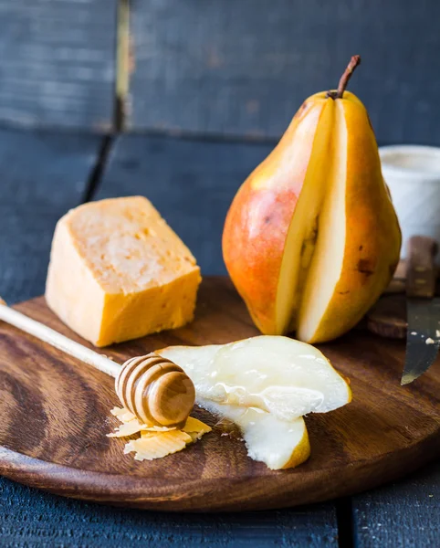 チーズと木の板の上に蜂蜜と新鮮なジューシーな梨 — ストック写真