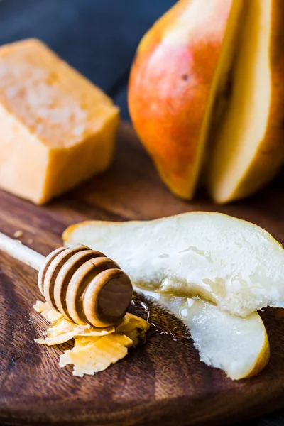チーズと木の板の上に蜂蜜と新鮮なジューシーな梨 — ストック写真