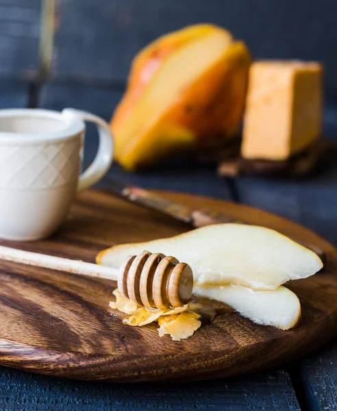 Frische saftige Birne mit Käse und Honig auf einem Holzbrett — Stockfoto