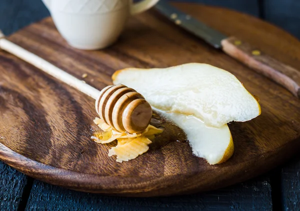 Peral fresca y jugosa con queso y miel en una tabla de madera —  Fotos de Stock