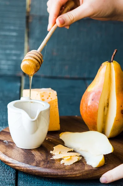 Pêra suculenta fresca com queijo e mel em uma tábua de madeira Fotografias De Stock Royalty-Free