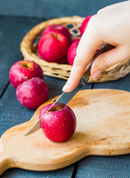 Bir bıçak taze kırmızı elma ile bir tahta masa, meyve kesme — Stok fotoğraf