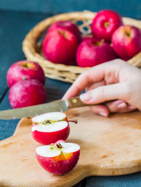 Cortado con un cuchillo manzanas rojas frescas en una tabla de madera, frutas — Foto de Stock