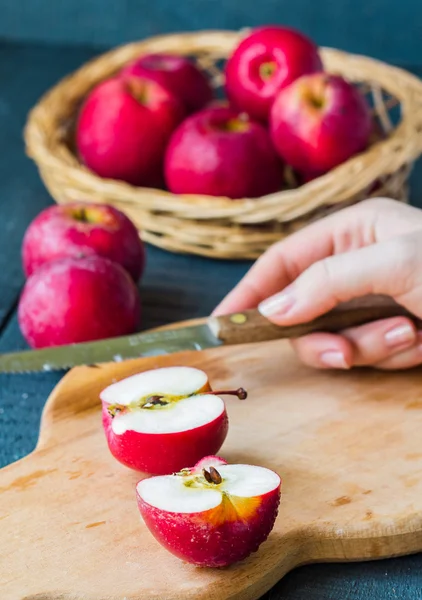 Cortado con un cuchillo manzanas rojas frescas en una tabla de madera, frutas — Foto de Stock