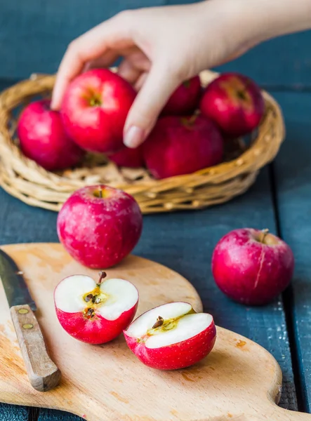 Cortado por la mitad de manzanas rojas frescas en una tabla de madera, frutas — Foto de Stock