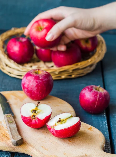 Cortado por la mitad de manzanas rojas frescas en una tabla de madera, frutas — Foto de Stock