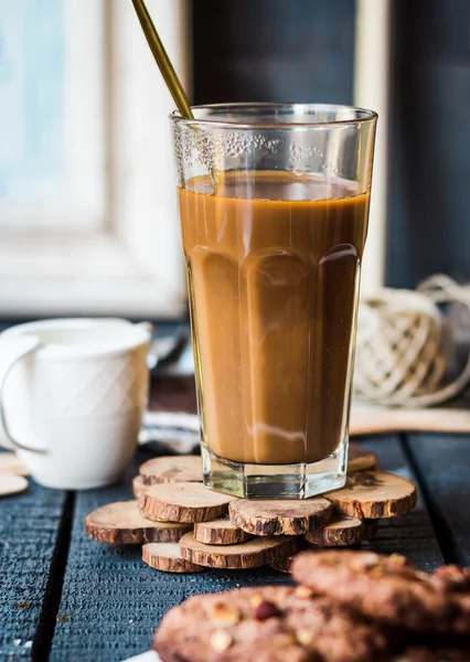 Café con leche en un vaso con una galleta de chocolate —  Fotos de Stock