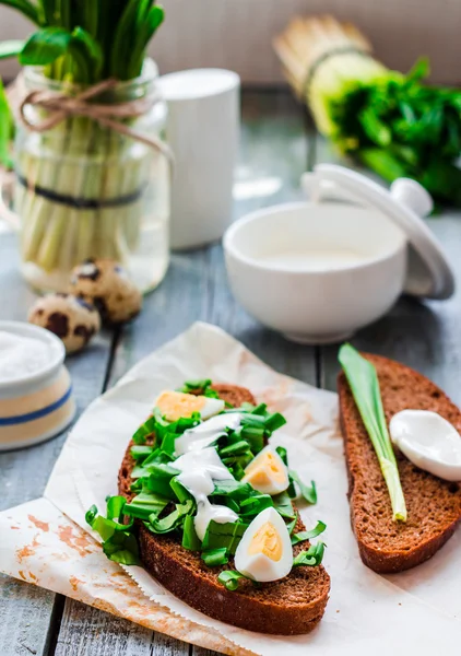 Pan de centeno con ajo silvestre, crema agria y huevos de codorniz —  Fotos de Stock