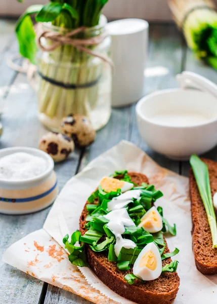 Rye bread with wild garlic, sour cream and quail eggs — Stock Photo, Image