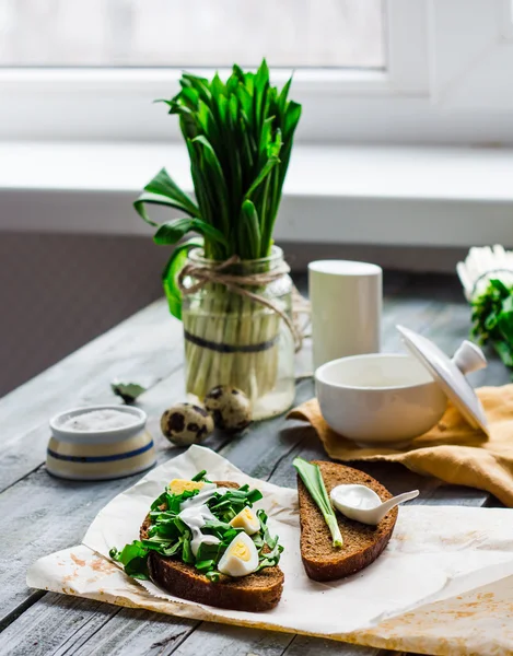 Pan de centeno con ajo silvestre, crema agria y huevos de codorniz —  Fotos de Stock