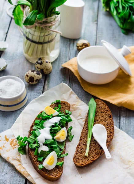 Rye bread with wild garlic, sour cream and quail eggs — Stock Photo, Image