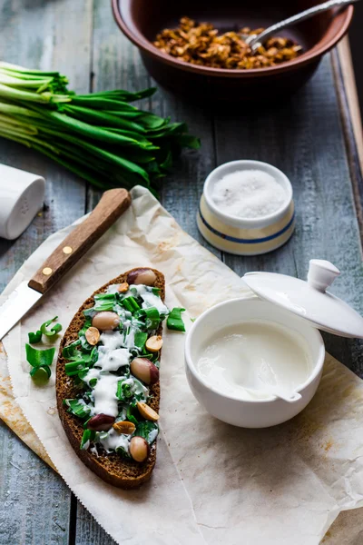 Roggebrood met wild knoflook, zure room en kwarteleitjes en bonen — Stockfoto