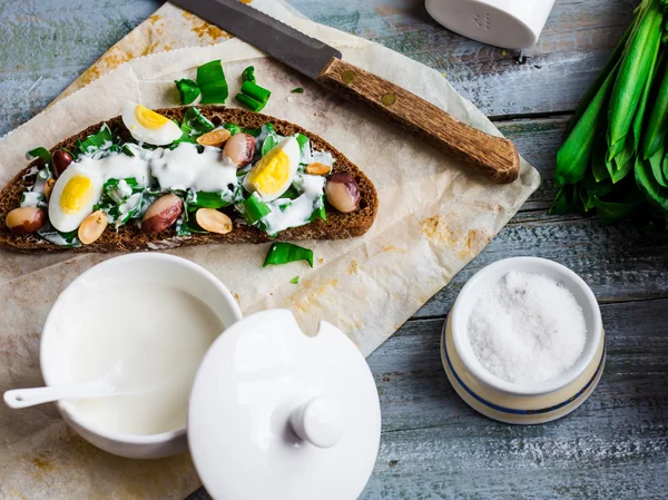 Pan de centeno con ajo silvestre, crema agria y huevos de codorniz y frijoles — Foto de Stock