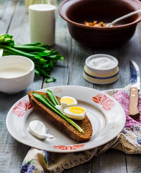 Yabani sarımsak, ekşi krema ve bıldırcın yumurtası ile çavdar ekmeği — Stok fotoğraf