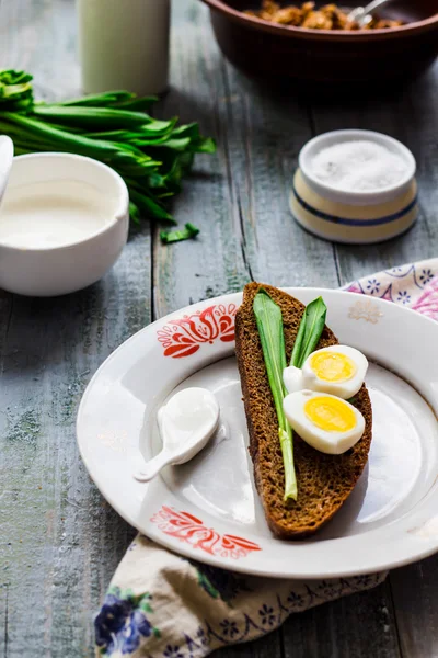 Pan de centeno con ajo silvestre, crema agria y huevos de codorniz —  Fotos de Stock