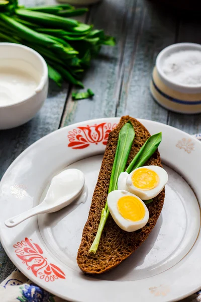Yabani sarımsak, ekşi krema ve bıldırcın yumurtası ile çavdar ekmeği — Stok fotoğraf