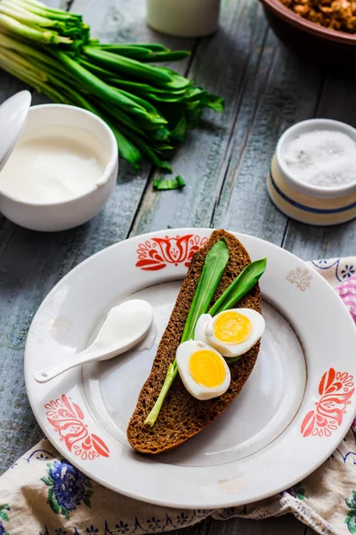 Pan de centeno con ajo silvestre, crema agria y huevos de codorniz —  Fotos de Stock