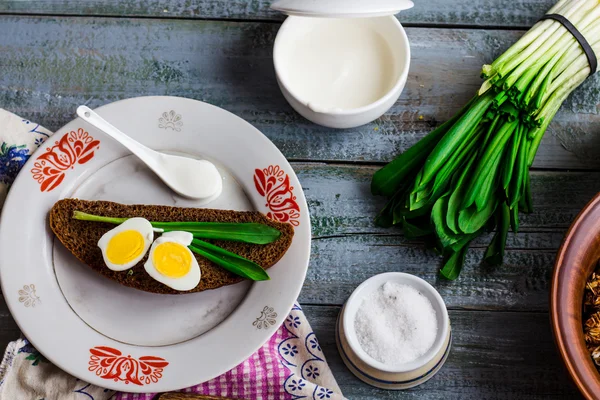 Pan de centeno con ajo silvestre, crema agria y huevos de codorniz —  Fotos de Stock