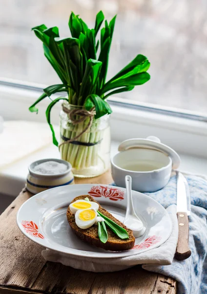 Leek with quail eggs and sour cream on rye bread, snack — Stock Photo, Image