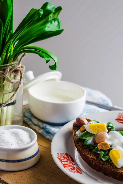 Leek with quail eggs and sour cream on rye bread, snack — Stock Photo, Image