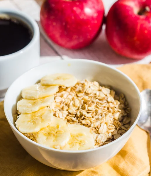 Oatmeal with bananas, apples and a cup of coffee — Stock Photo, Image