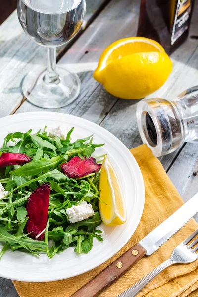 Green salad with arugula beet and goat cheese, lemon, organic fo — Stock Photo, Image