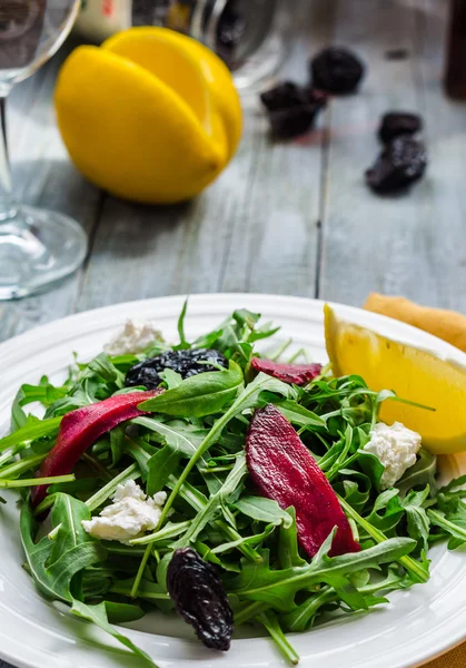 Insalata verde chiaro di rucola con barbabietole, formaggio di capra e prugne secche — Foto Stock