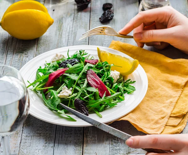 Mangiare insalata verde con rucola, barbabietole, formaggio di capra e olive oi — Foto Stock