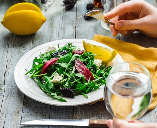 Mangiare insalata verde con rucola, barbabietole, formaggio di capra e olive oi — Foto Stock