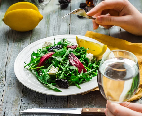 Mangiare insalata verde con rucola, barbabietole, formaggio di capra e olive oi — Foto Stock