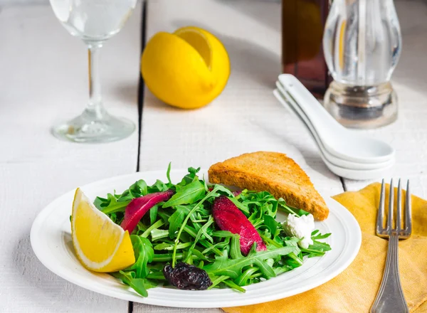 Insalata verde chiaro con rucola, barbabietole, formaggio di capra e prugne secche — Foto Stock