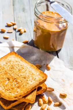 Fıstık ezmesi kahvaltıda, closeup ile kırmızı gevrek ekmek