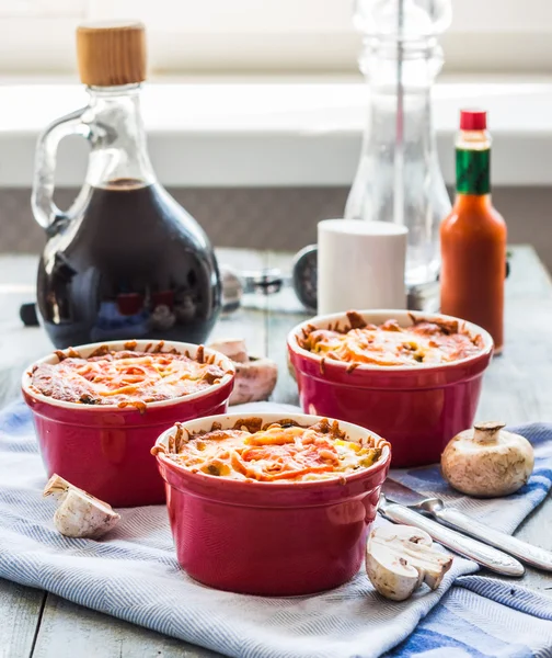Гриб Жюльен с помидорами и сыром в красных горшках — стоковое фото