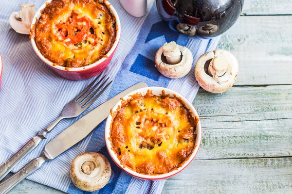 Julienne de champignons cuits au four avec tomate et fromage dans des pots rouges — Photo