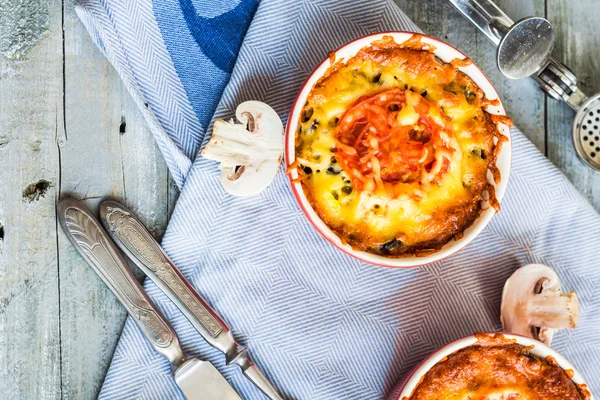 Julienne de champignons cuits au four avec tomate et fromage dans des pots rouges — Photo