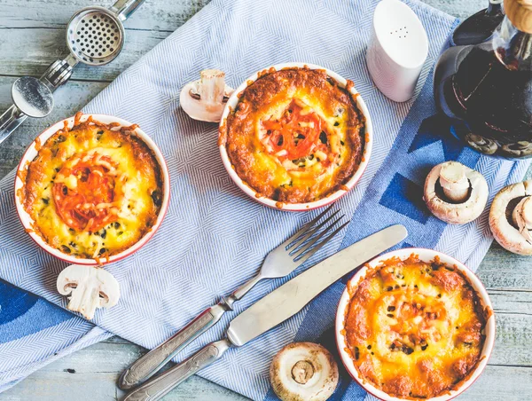 Baked mushroom julienne with tomato and cheese in red pots