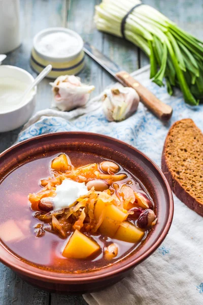 Red soup with beans, beets, cabbage and potatoes, sour cream — Stock Photo, Image