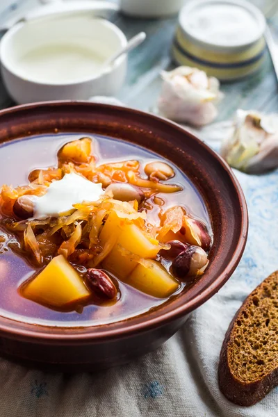 Red soup with beans, beets, cabbage and potatoes, sour cream — Stock Photo, Image