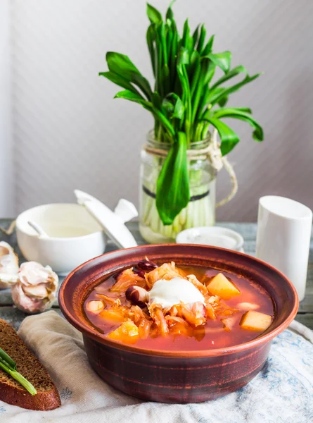 Borscht vermelho com creme de leite, alho selvagem, pão preto, rústico — Fotografia de Stock