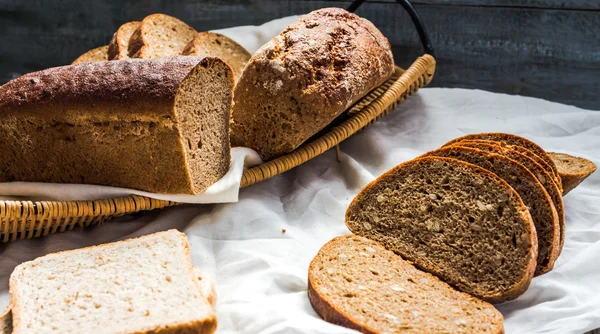 Sortierte Brotscheiben in einem Korb auf einem weißen Leinentischtuch — Stockfoto