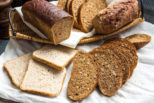 Sortierte Brotscheiben in einem Korb auf einem weißen Leinentischtuch — Stockfoto