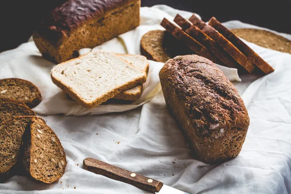 Pane assortito, fette di pane di segale su tovaglie di lino, legno — Foto Stock