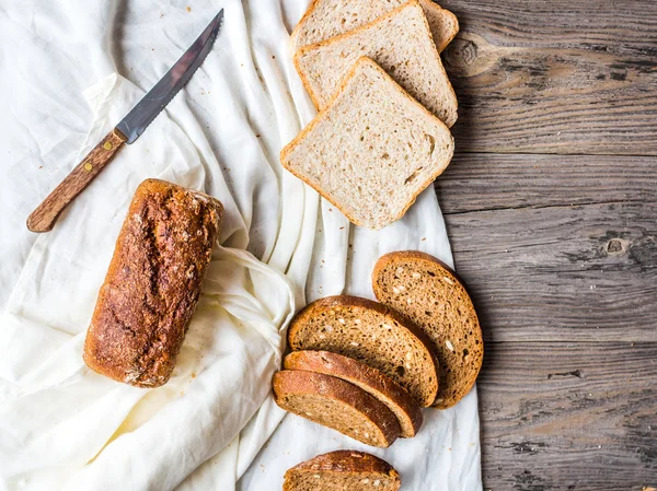 Pan surtido, rebanadas de pan de centeno en manteles de lino, madera —  Fotos de Stock