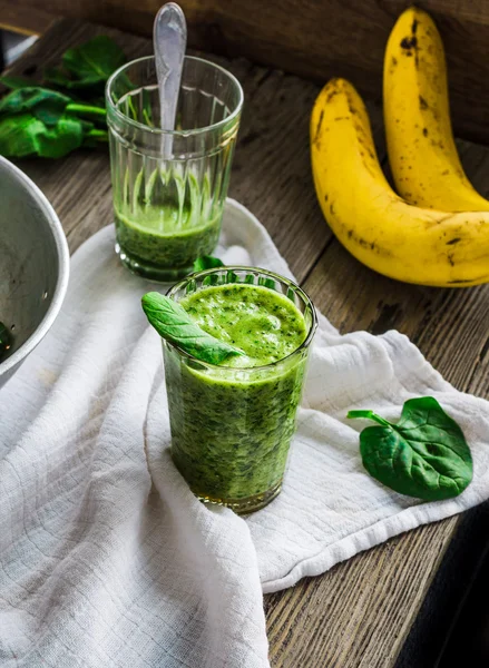 Grøn smoothie med spinatblade, banan med jordnøddemælk i en - Stock-foto