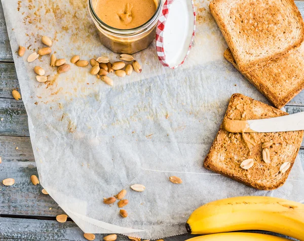 Knuspriger Toast mit Erdnussbutter, Bananen, Frühstück, Draufsicht — Stockfoto