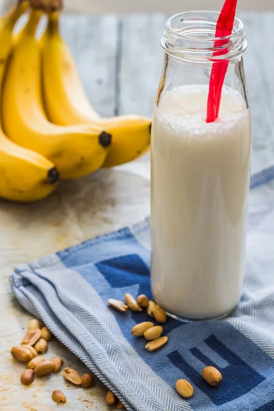 Банановий коктейль з арахісовим маслом, запечений арахіс, напій — стокове фото